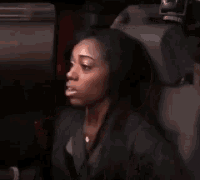 a woman is sitting in the driver 's seat of a car with her mouth open .