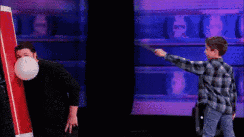 a man is blowing up a balloon while a boy throws a frisbee