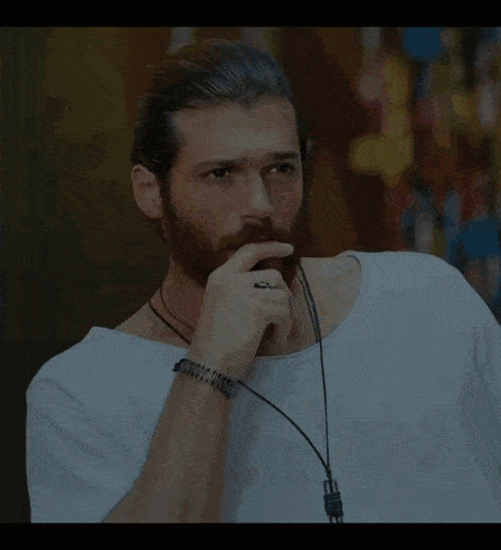 a man with a beard is wearing a white shirt