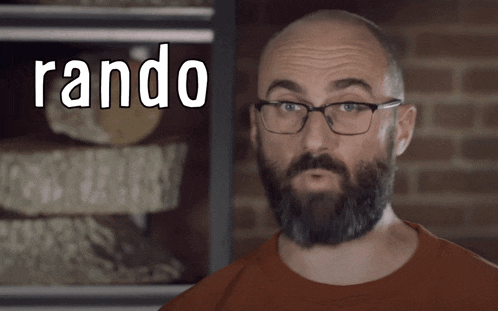 a bald man with glasses and a beard is standing in front of a sign that says rando