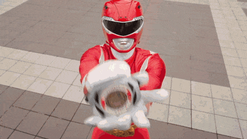 a red power ranger is holding a red lightning bolt in his hand