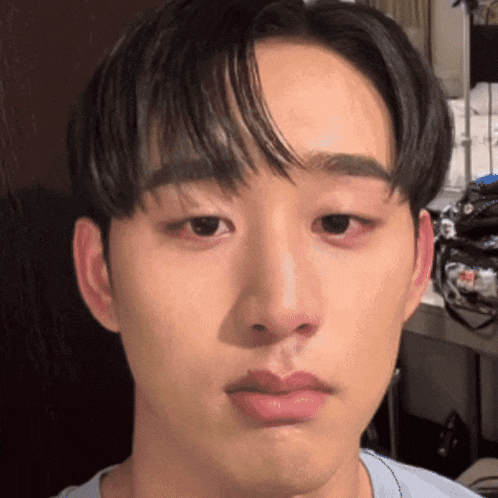 a close up of a young man 's face with a blue shirt on