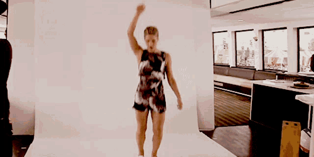 a woman in a dress is dancing in front of a white background