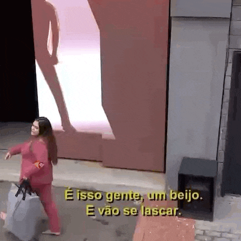 a woman is walking down a street with a suitcase and a man is standing in front of a large screen .