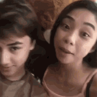 a boy and a girl are posing for a picture together .
