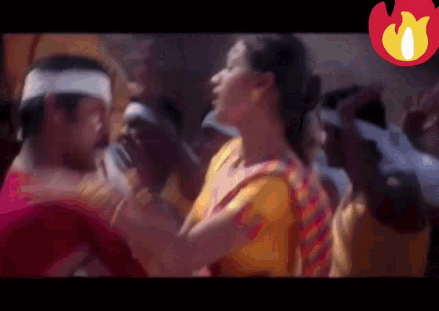 a group of people are dancing in a room with a fire in the corner .