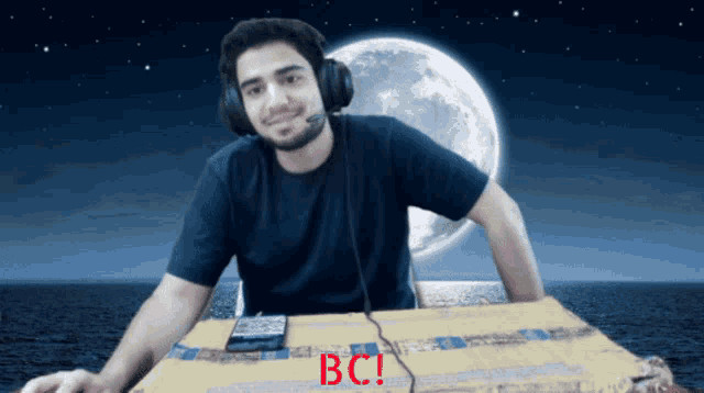 a man wearing headphones sits at a table with bc written in red letters