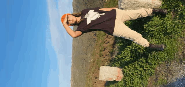a person wearing a black shirt with a white eagle on it laying on the ground