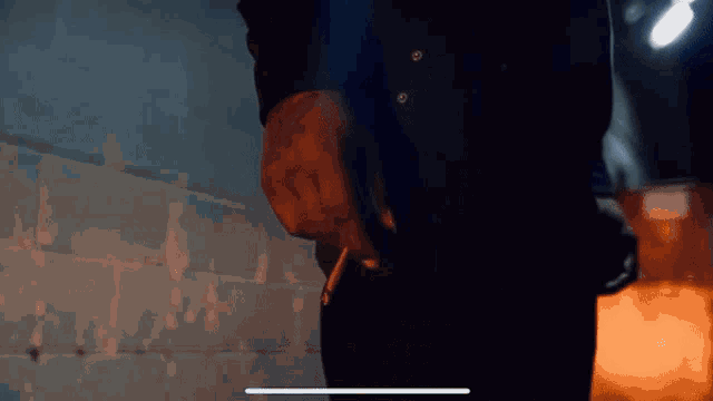 a man in a hooded sweatshirt is smoking a cigarette and smoke is coming out of his mouth .