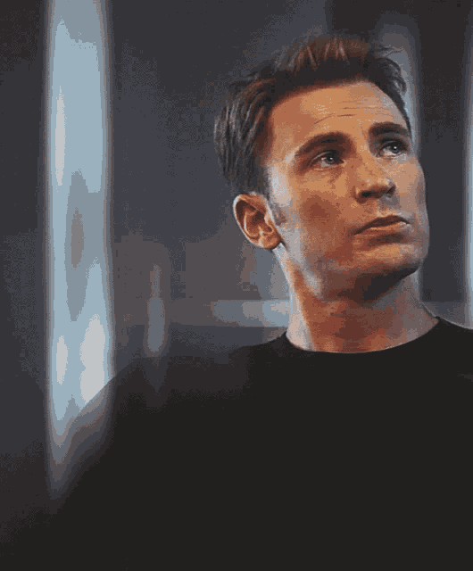 a close up of a man 's face with his eyes closed in a dark room