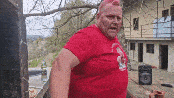 a man wearing a red shirt with a picture of a man with a mohawk