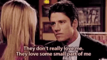 a man in a suit and bow tie is talking to a woman in a bar .