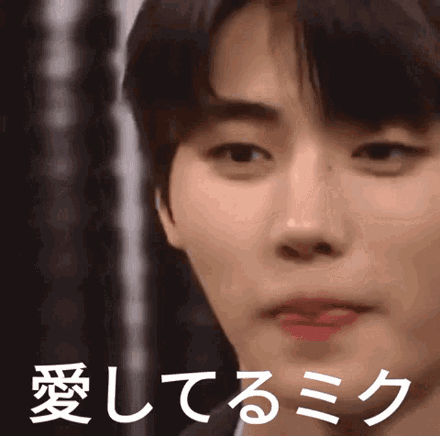a close up of a man 's face with japanese writing on it .