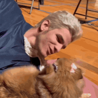 a man laying on the floor with a dog on his chest