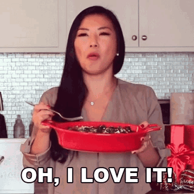 a woman is holding a bowl of food and saying oh , i love it
