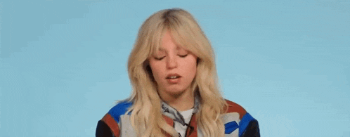 a close up of a woman with blonde hair making a funny face .