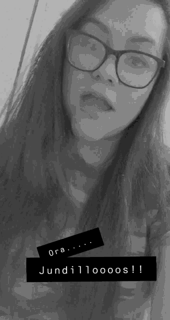 a black and white photo of a girl wearing glasses and a sticker that says " ora "
