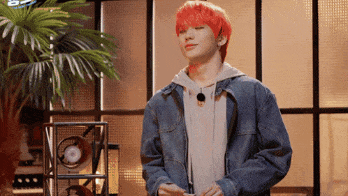 a young man with red hair is wearing a denim jacket