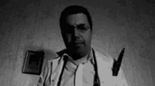 a black and white photo of a doctor with a stethoscope around his neck .