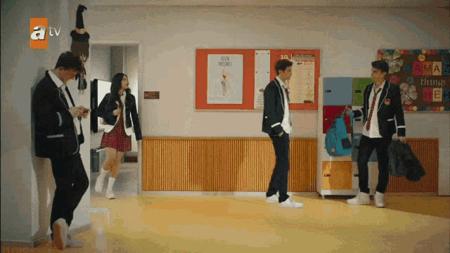 a group of students walking in a hallway with a tv logo on the bottom