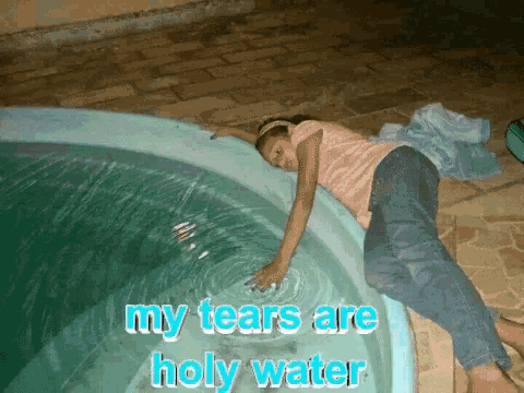 a girl is laying in a pool with the words " my tears are holy water " on the bottom