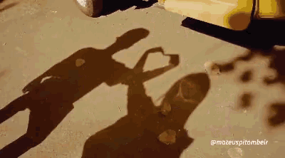 a shadow of a woman making a heart shape with her hands