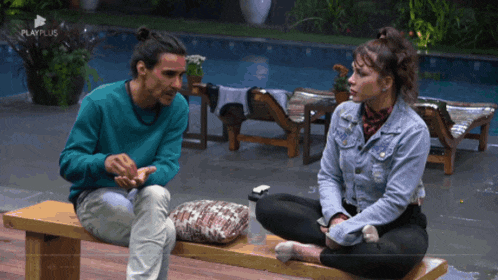 a man and a woman sit on a bench in front of a pool with playplus written on the bottom of the screen