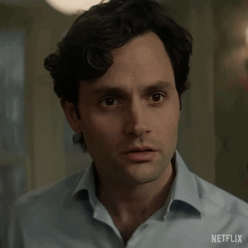 a close up of a man 's face with a surprised look on his face in a blue shirt .