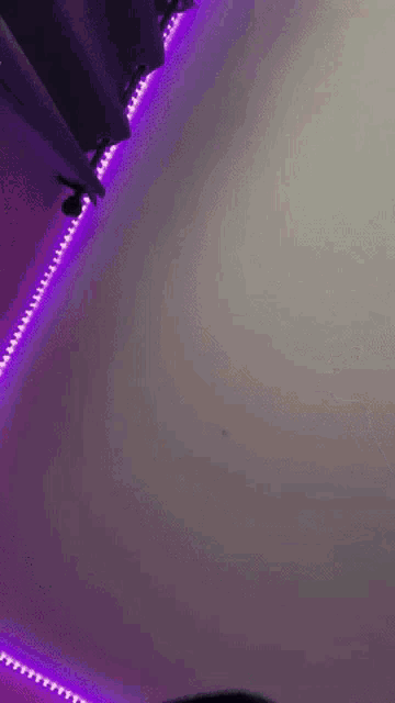 a person is standing in front of a purple light on the ceiling .