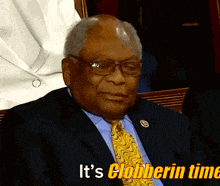 a man in a suit and tie with the words it 's clobberin time above him