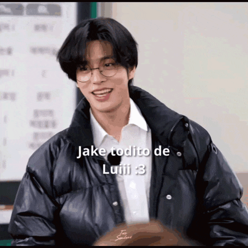 a young man wearing glasses and a black jacket says " jake todito de luiii "