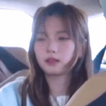 a young girl is sitting in the back seat of a car .