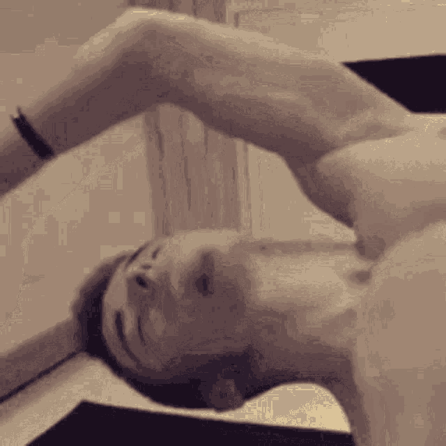 a man without a shirt is laying down with his eyes closed