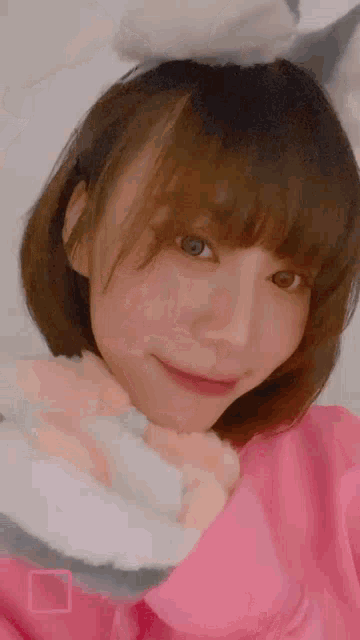 a woman wearing a pink sweater and bunny ears