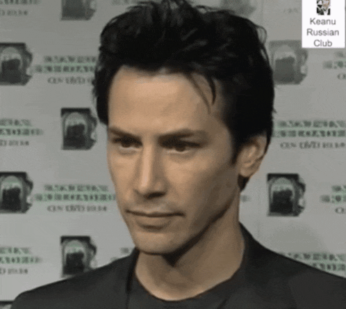 a man is standing in front of a wall that says keanu russian