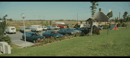 a lot of cars are parked in a parking lot in front of a restaurant