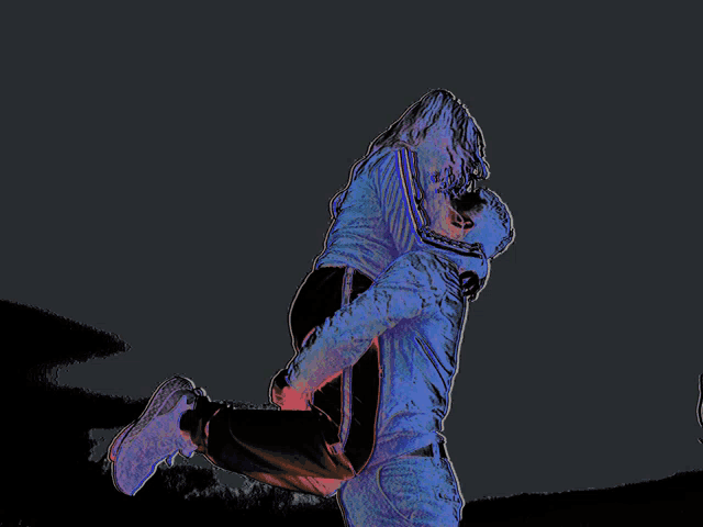 a man is carrying a woman in his arms in a dark room