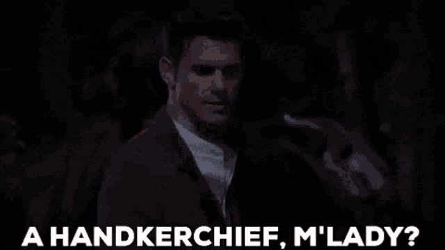 a handkerchief , m ' lady ? is being held in someone 's hand in a dark room .