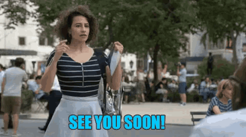 a woman in a striped shirt and a white skirt is walking in a park and says see you soon .