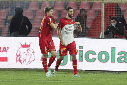 two soccer players on a field with one wearing a shirt that says ' io ho purgato ancora '