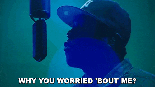 a man wearing a ny hat is standing in front of a microphone and says why you worried bout me