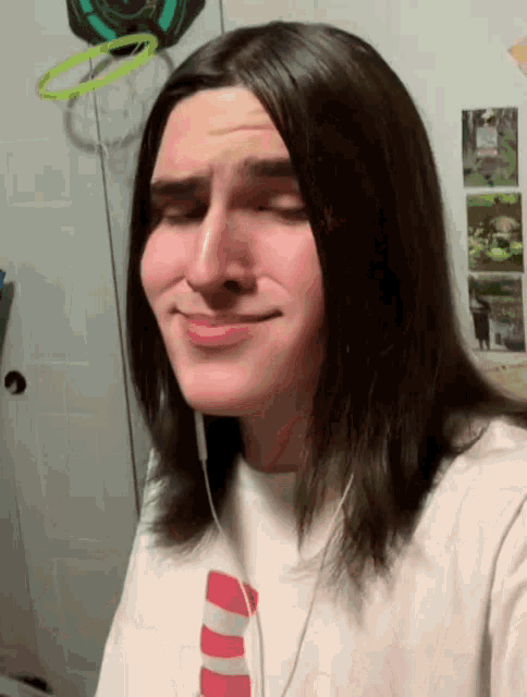 a young man with long hair is wearing headphones