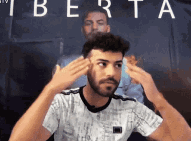 a man with a beard is making a funny face in front of a sign that says berta