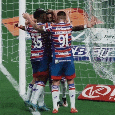 a group of soccer players with one wearing the number 91 jersey