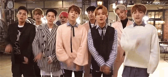 a group of young men are standing next to each other in a row .