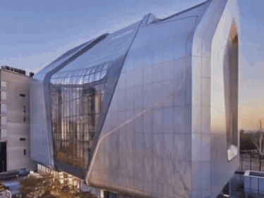 a very large building with a lot of windows and a blue sky behind it