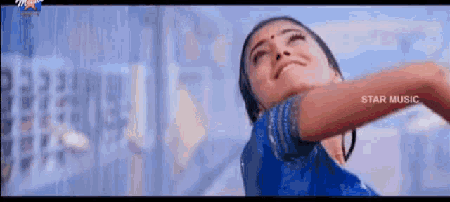 a woman in a blue dress is dancing in front of a star music logo ..