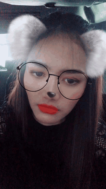 a woman wearing glasses and furry ears has red lipstick