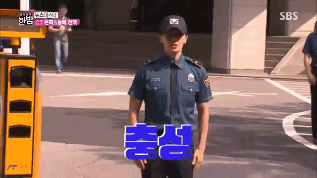 a man in a police uniform is standing in front of a yellow trash can and a sign that says sbs on it