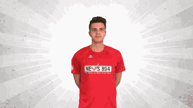 a man wearing a red shirt that says news 894 on it